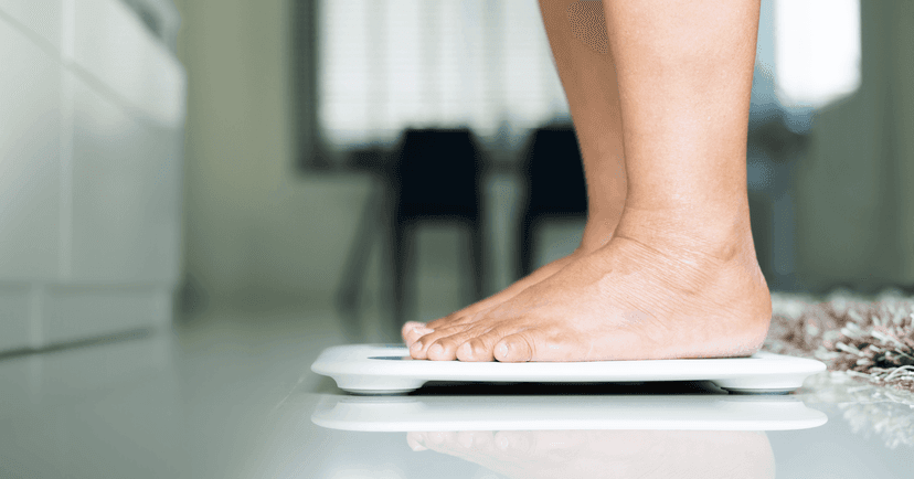 woman standing on a scale experiencing distress over her appearance
