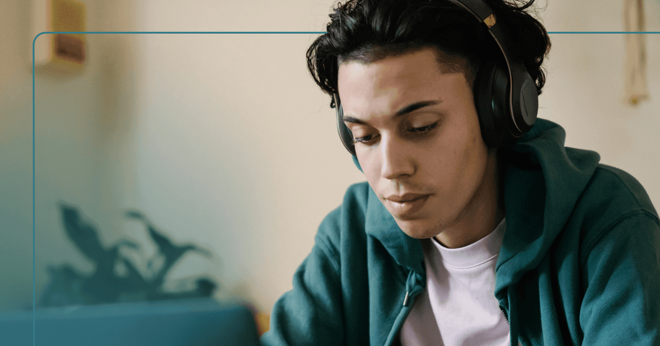 A teenager in a green hoodie with dark hair and headphones on looks down at a laptop with a neutral face. A plant is out of focus in the background.