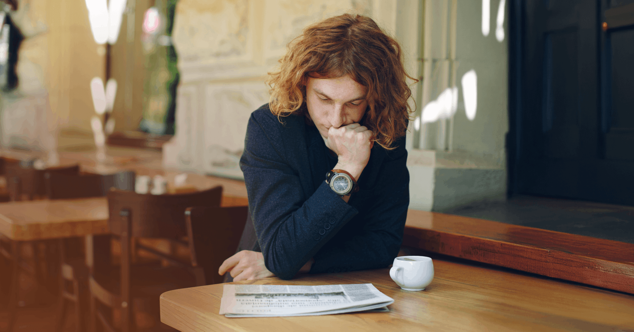 man feeling helpless while reading the newspaper