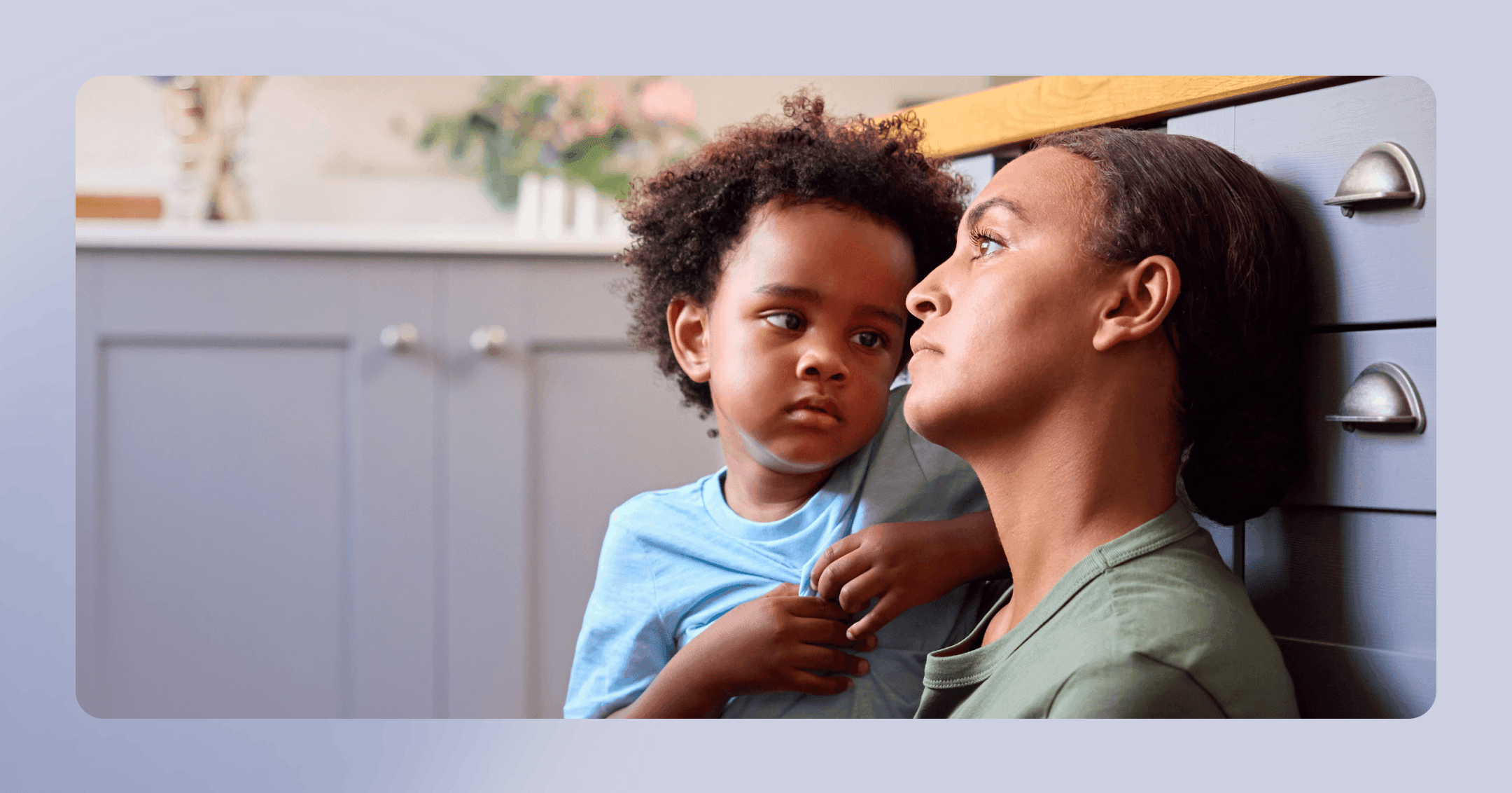 woman with ptsd sits with her son in a kitchen