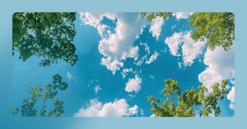Image shows an aerial view of the sky. White clouds are against bright blue with green trees visible. There is a blue border around the outside scene.